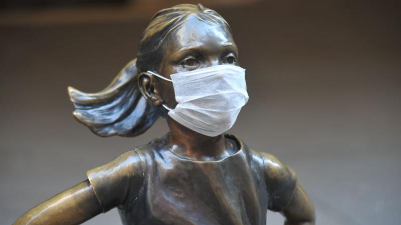 'Fearless Girl' statue stands across from the New York Stock Exchange wearing a coronavirus mask