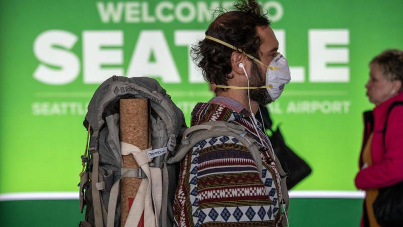 Passenger prepares to board a flight out of Seattle amid concern surrounding the coronavirus