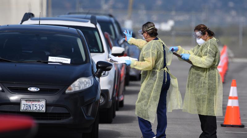Health care workers in a drive-through coronavirus test