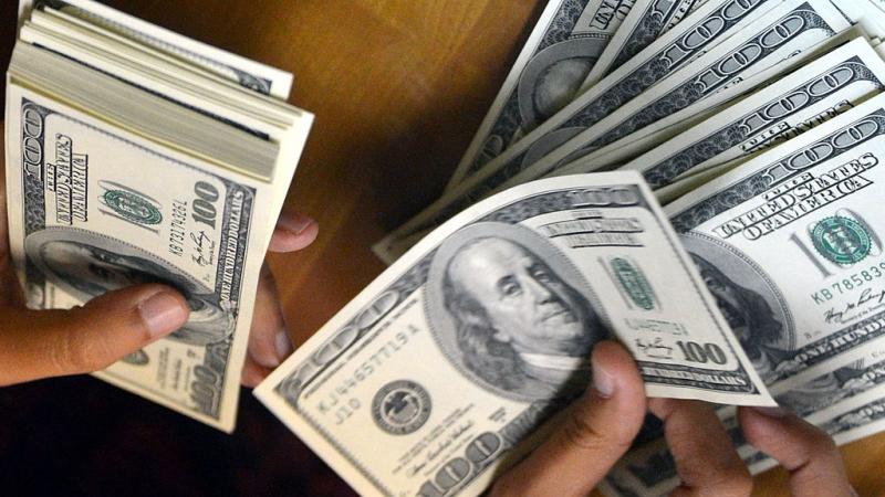 Person counts U.S. money at money change outlet in Jakarta in 2013