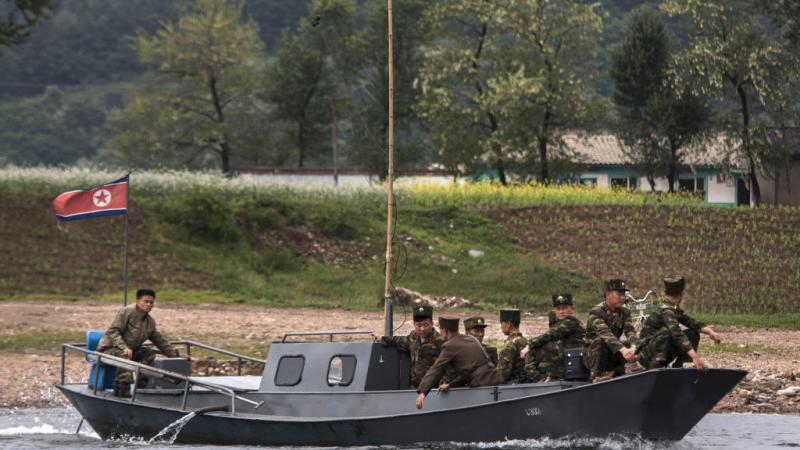North Korean soldiers cross the Yalu river near the Chinese border city of Dandong