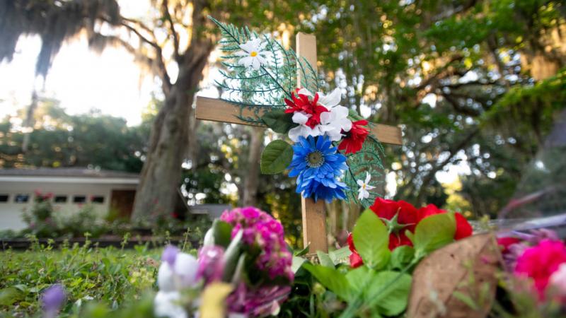 Cross with flowers on May 7 in the neighborhood where Ahmaud Arbery was killed