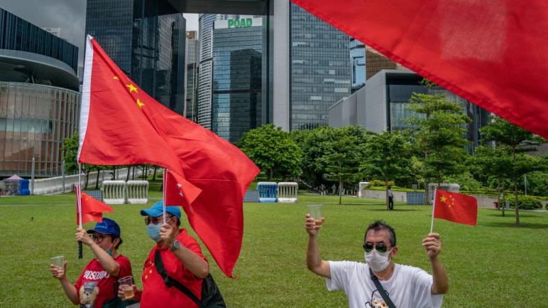 Pro-Beijing supporters wave flags during a rally celebrating a new national security law