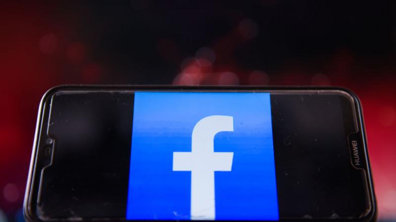 Photo illustration of a Facebook logo on a smartphone