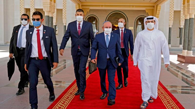 The Head of Israel's National Security Council, Meir Ben-Shabbat (2nd-R), wearing a protective mask, makes his way to board the plane as he prepares to leave Abu Dhabi on September 1, 2020.