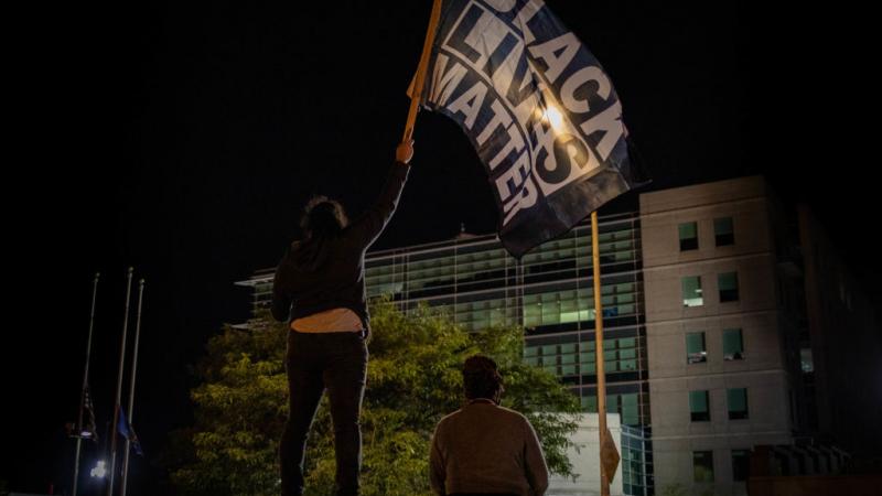 Black Lives Matter protestors waves flag 