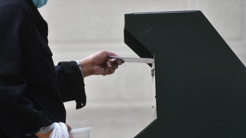 A voter mailing a ballot at a post office box