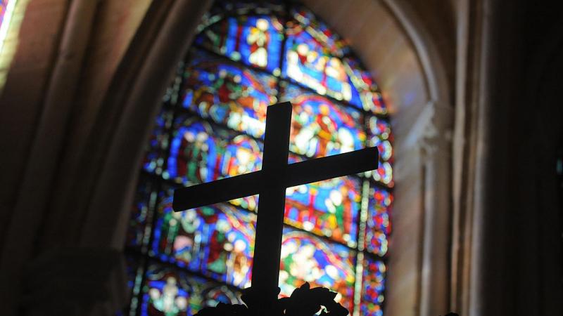 Cross in front of stained glass window