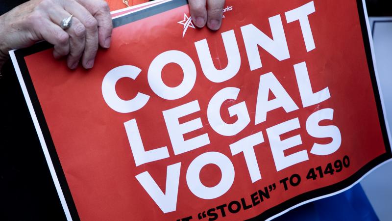 A supporter of U.S. president Donald Trump holds a sign during a protest outside the Philadelphia Convention center.