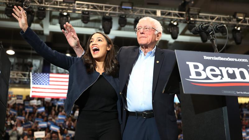 U.S. Rep. Alexandria Ocasio-Cortez (D-N.Y) and Democratic presidential candidate Sen. Bernie Sanders (I-VT) stand together during his campaign event at the Whittemore Center Arena on February 10, 2020 in Durham, New Hampshire.