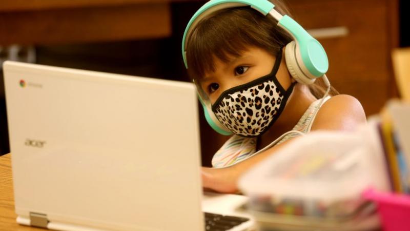 A student participates in a Zoom lesson from classroom.