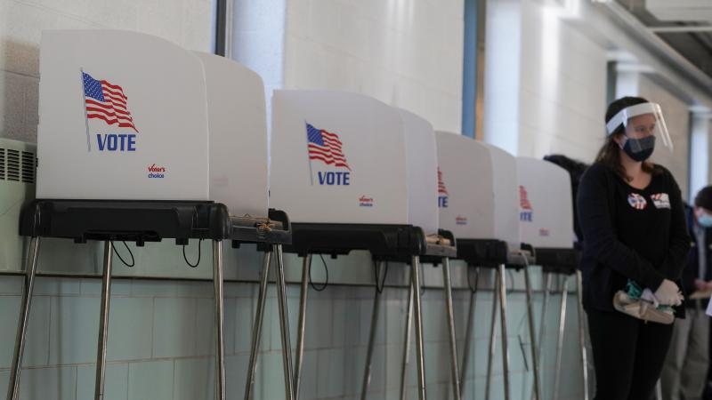 A poll worker stands by voting booths at Western High School as residents of Baltimore City cast their votes in the U.S. Presidential and local congressional elections on November 03, 2020 in Baltimore, Maryland.