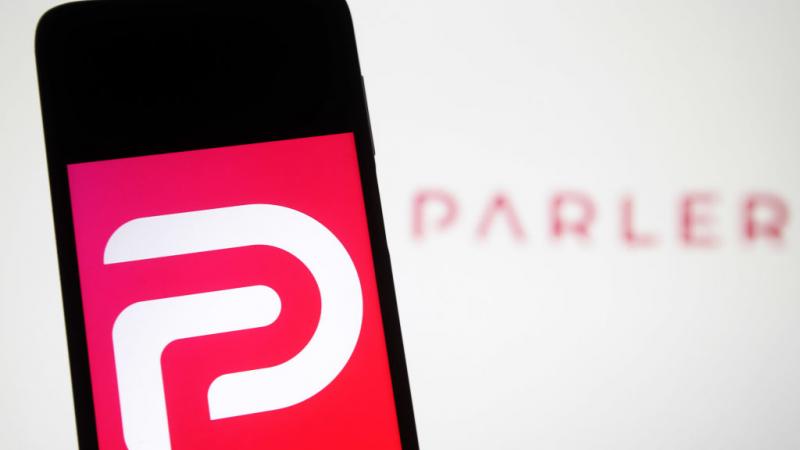 Parler logo displayed on phone in photo illustration
