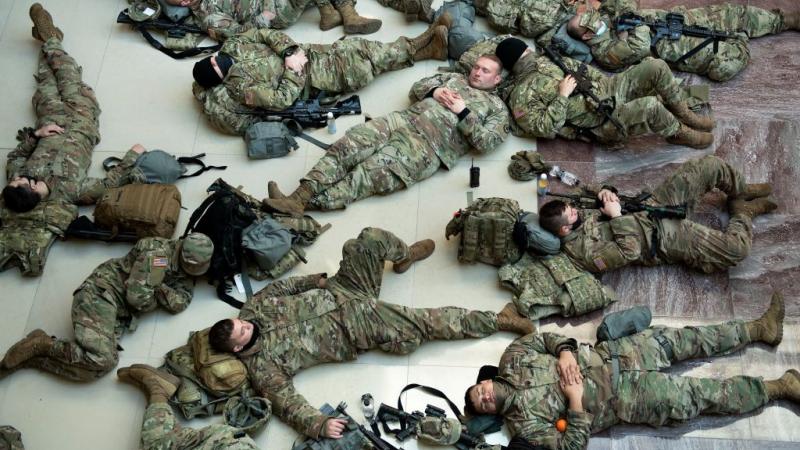 National Guard soldiers sleep on the marble floor inside the Capitol
