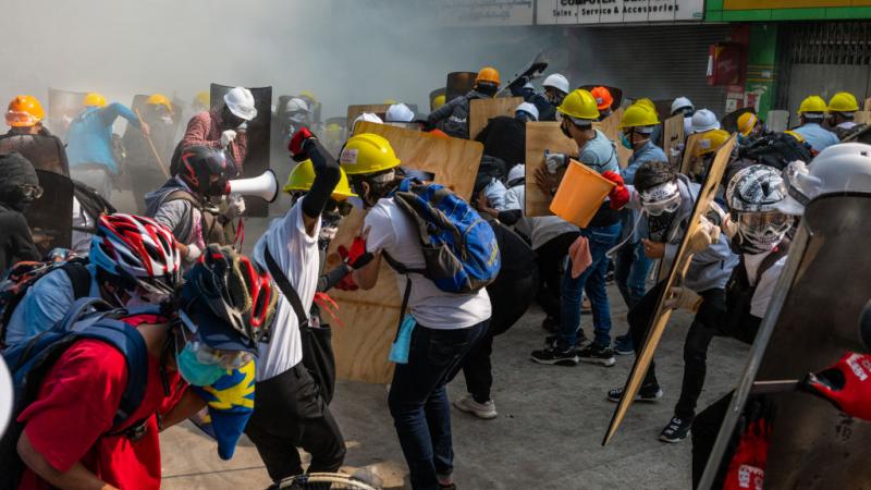 Protestors defend themselves in clashes with riot police in Myanmar on Feb. 28, 2021