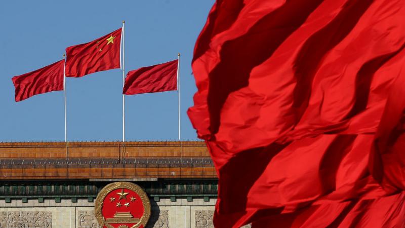 Chinese flag behind razor wire at housing compound in China
