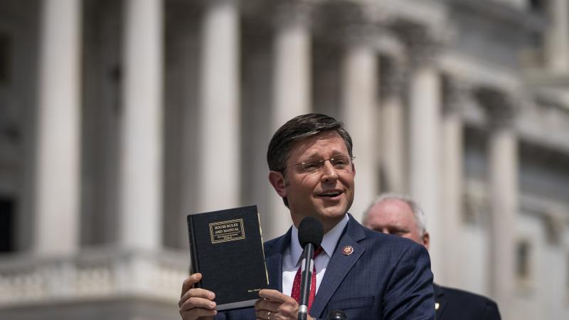 Rep. Mike Johnson (R-LA) holds up a House Rules and Manual book during a news conference outside the U.S. Capitol, May 27, 2020 in Washington, DC.