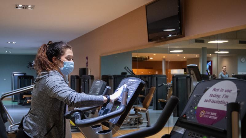 A member of staff cleans gym equipmet at David Lloyd health club in Leicester after closing for the last time ahead of a national lockdown for England from Thursday.