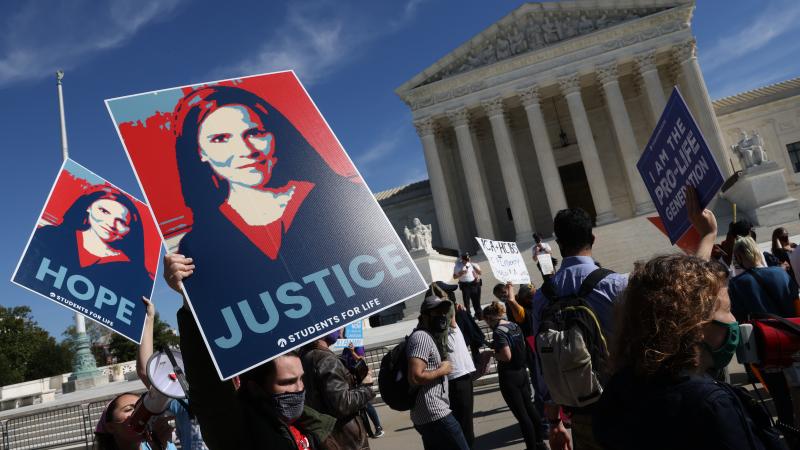 Supporters of Supreme Court nominee Judge Amy Coney Barrett with the group Students For Life demonstrate outside the Supreme Court as opponents of Barrett also protest in front of the building on the third day of her testimony on Capitol Hill on October 14, 2020 in Washington, DC.