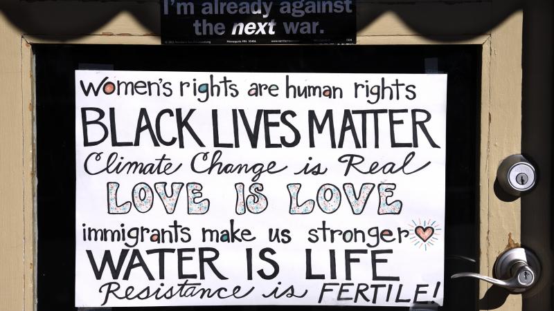 A handmade sign on the front door of a shop in Santa Fe, New Mexico, states the shop owner's left-of-center political and social beliefs and philosophy.