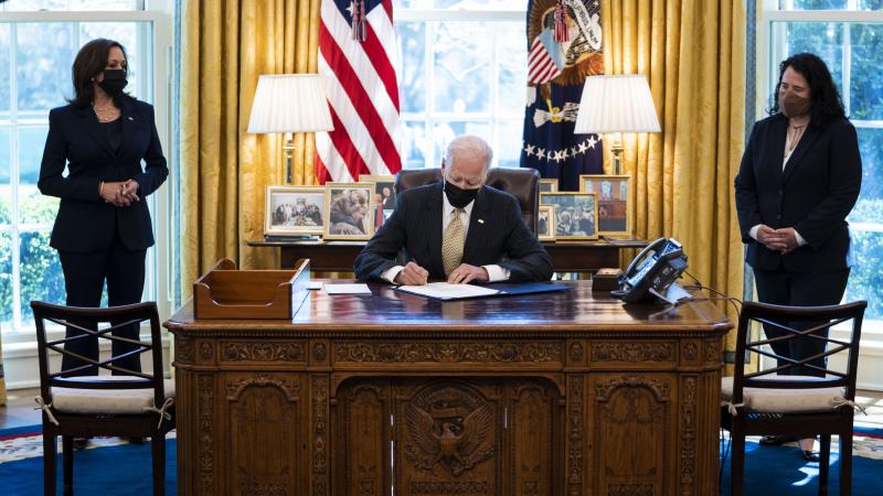 Flanked by Vice President Kamala Harris (L) and Administrator of the Small Business Administration (SBA) Isabella Casillas Guzman (R), U.S. President Joe Biden signs the Paycheck Protection Program (PPP) extension in the Oval Office of the White House on March 30, 2021 in Washington, DC.