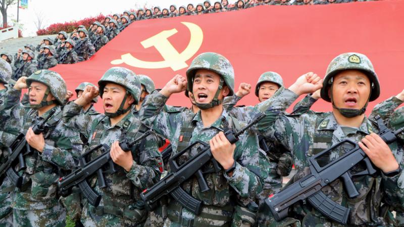 Chinese military in front of party flag