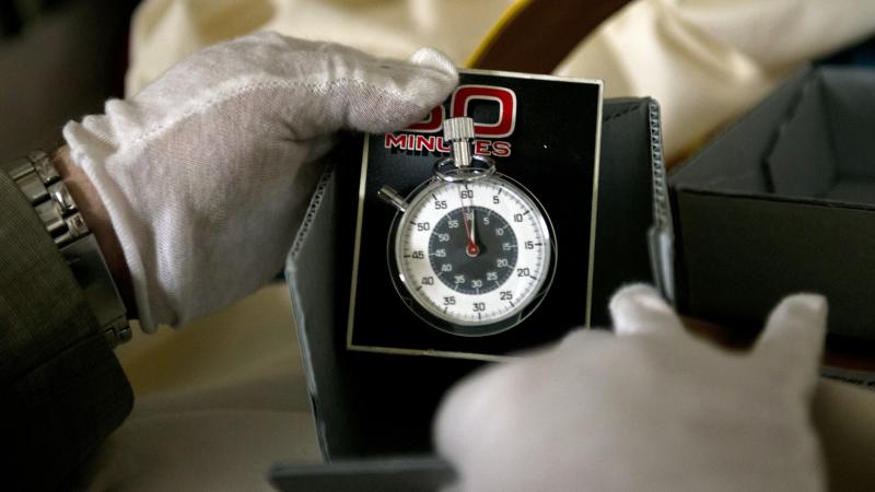 Dwight Bowers, Curator of Division of Culture and the Arts, holds the stopwatch used on the TV news magazine show "60 Minutes" in the vaults at the Smithsonian's American History Museum July 27, 2012 in Washington, DC.