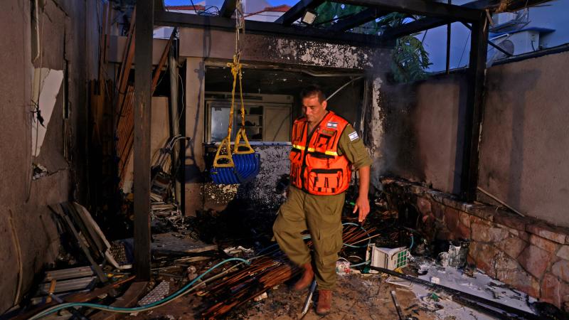 An Israeli soldier inspects a house hit by Palestinian rocket fire in the southern city of Ashkelon on May 12, 2021, amid the most intense Israeli-Palestinian hostilities in seven years.