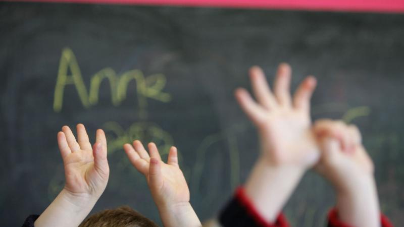 Children wave hands at a private nursery school in Scotland in 2005