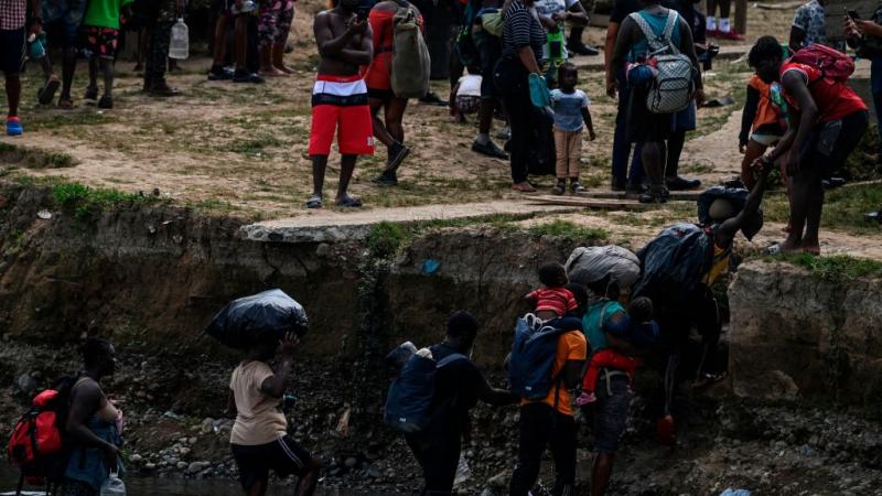 Migrants cross the Chucunaque river after walking for five days in the Darien Gap, in Bajo Chiquito villag