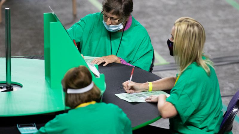 Contractors working for Cyber Ninjas, who was hired by the Arizona State Senate, examine and recount ballots from the 2020 general election at Veterans Memorial Coliseum on May 8, 2021 in Phoenix, Arizona.