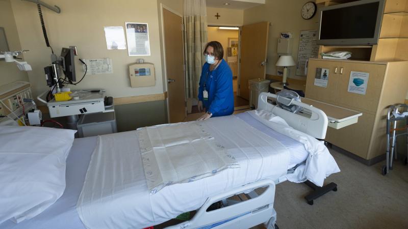 Nurse Manager Kobie Walsh, RN prepares a room on the general surgery floor at St. Joseph Hospital in Orange, CA on Thursday, March 4, 2021.