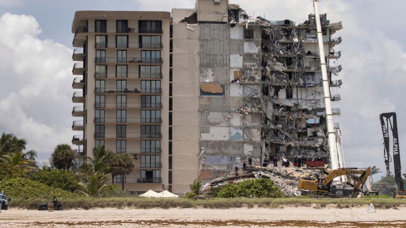 Members of the South Florida Urban Search and Rescue team search for survivors in partially collapsed Champlain Towers South in Florida