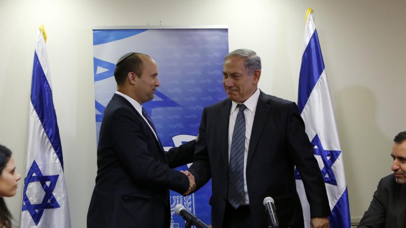 Israeli Prime Minister Benjamin Netanyahu (R) shakes hands with the head of the right-wing Jewish Home party, Naftali Bennett as they arrive to give a press conference at the Knesset in Jerusalem, on May 6, 2015, to announce the formation of a coalition government.
