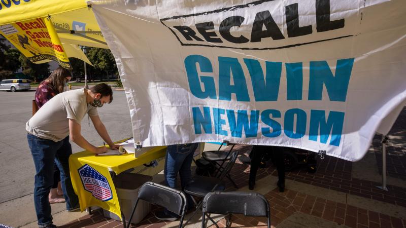 A man signs a petition as conservative activists gather signatures in a recall effort against California Governor Gavin Newsom near Pasadena City Hall, in Pasadena, California on February 28, 2021