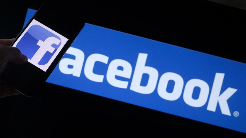 This illustration photo shows the Facebook logo on a smartphone in front of a computer screen in Los Angeles on August 12, 2021.