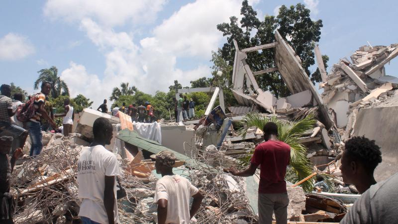People search through the rubble of what used to be the Manguier Hotel after the earthquake hit on August 14, 2021 in Les Cayes, southwest Haiti.