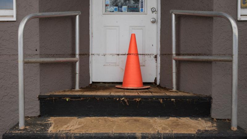 A muddy waterline appears against a business entrance after a flash flood hit the area, following Tropical Storm Henris landfall, in Jamesburg, New Jersey, on August 23, 2021.