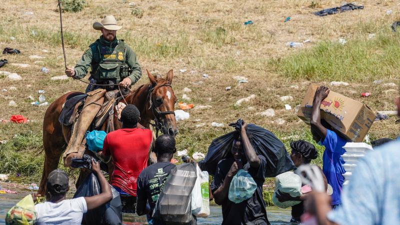  A United States Border Patrol agent on horseback uses the reins as he tries to stop Haitian migrants from entering an encampment on the banks of the Rio Grande near the Acuna Del Rio International Bridge in Del Rio, Texas on September 19, 2021.