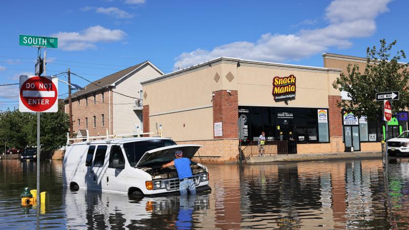 Abilio Viegas attempts to fix his flooded van on South Street on September 02, 2021 in Newark, New Jersey.