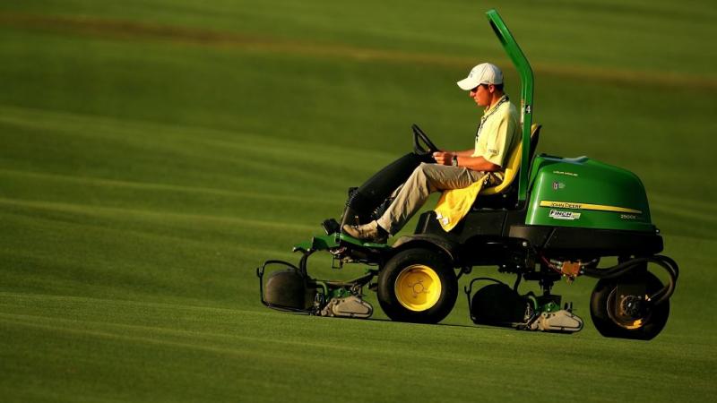 Grounds crew at the U.S. open operate John Deere mowers