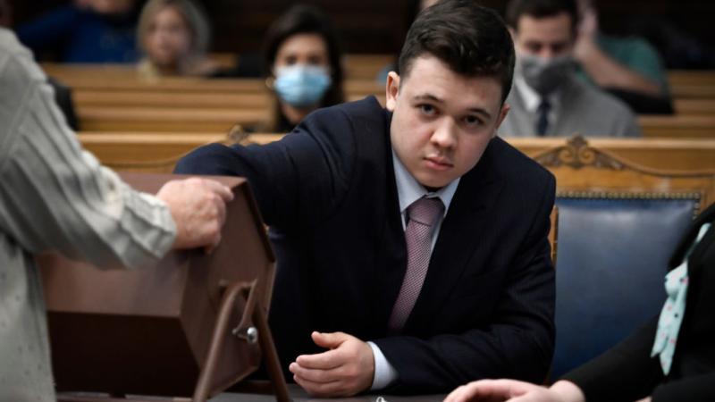 Kyle Rittenhouse pulls numbers of jurors out of a tumbler during his trial at the Kenosha County Courthouse 