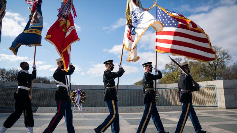 : A military honor guard arrives at the World War II Memorial for a wreath-laying ceremony to mark National Pearl Harbor Remembrance Day on December 7