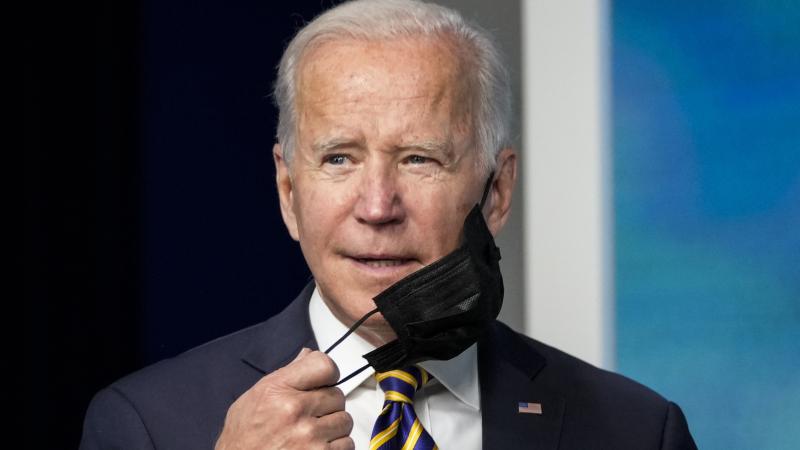 President Joe Biden removes his mask, Washington, D.C., Oct. 14, 2021
