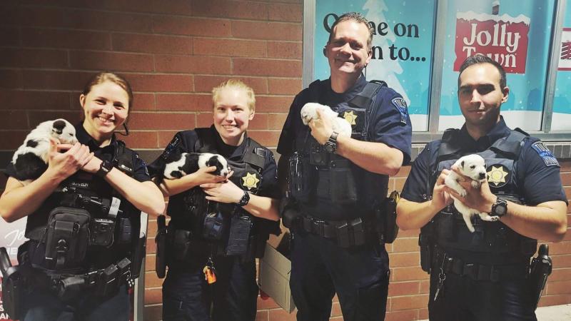 Tulsa police officers hold puppies, Dec. 25, 2021