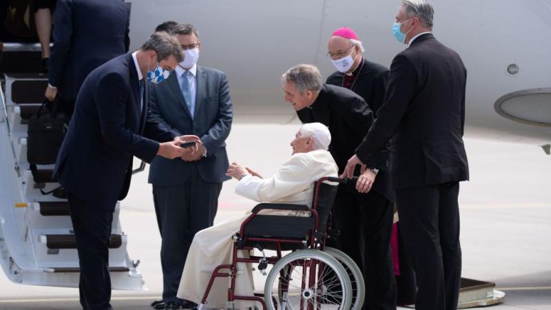 Bavaria's State Premier Markus Soeder (L) is given a medal by former pope Benedict XVI at the airport in Munich, southern Germany