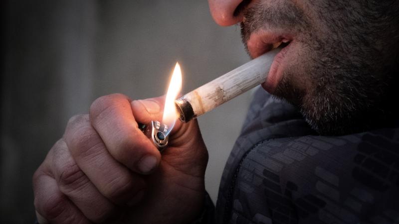 Oussman, a crack addict lights a pipe at Stalingrad Square, nicknamed Stalincrack, on December 2, 2020 in Paris.