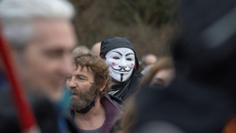 A protester in an 'Anonymous'-style mask
