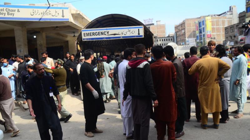 People gather around emergency service after a suicide bomber blew himself up during weekly Friday prayers at a Shia mosque in northwestern Pakistan, killing at least 30 people and injuring over 50 others, on March 4, 2022
