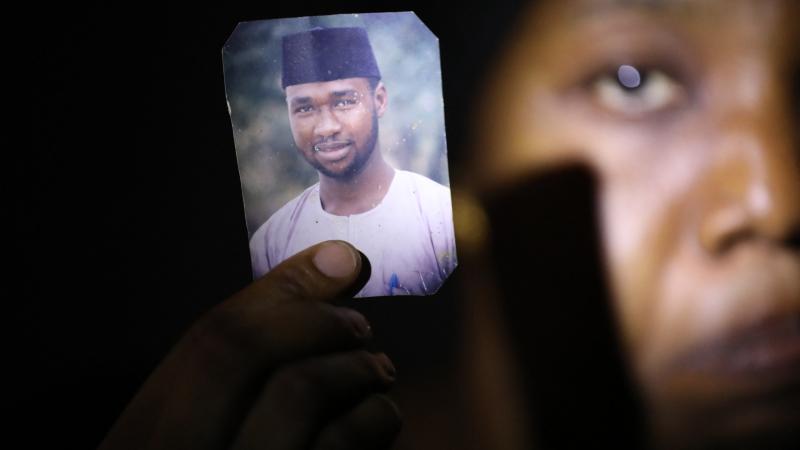 Amina Ahmed, wife of Mubarak Bala, holds up his photo, Nigeria, April 11, 2021